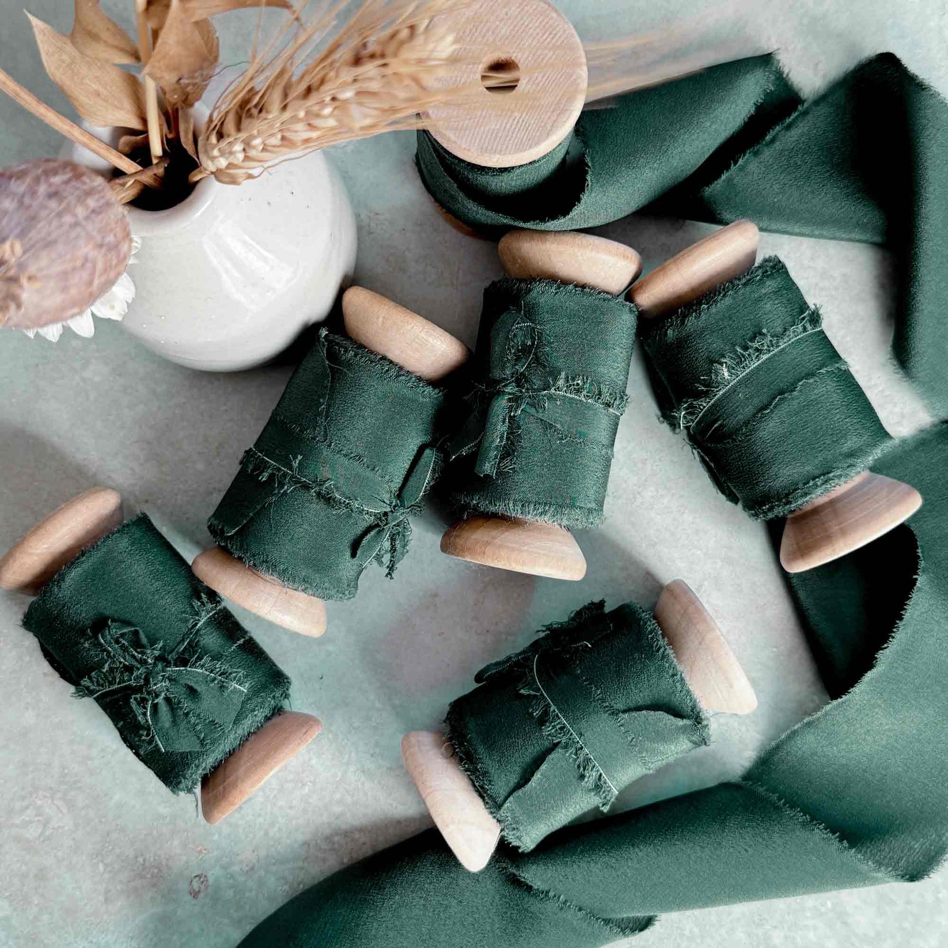 dark green wide silk ribbon on a wooden reel