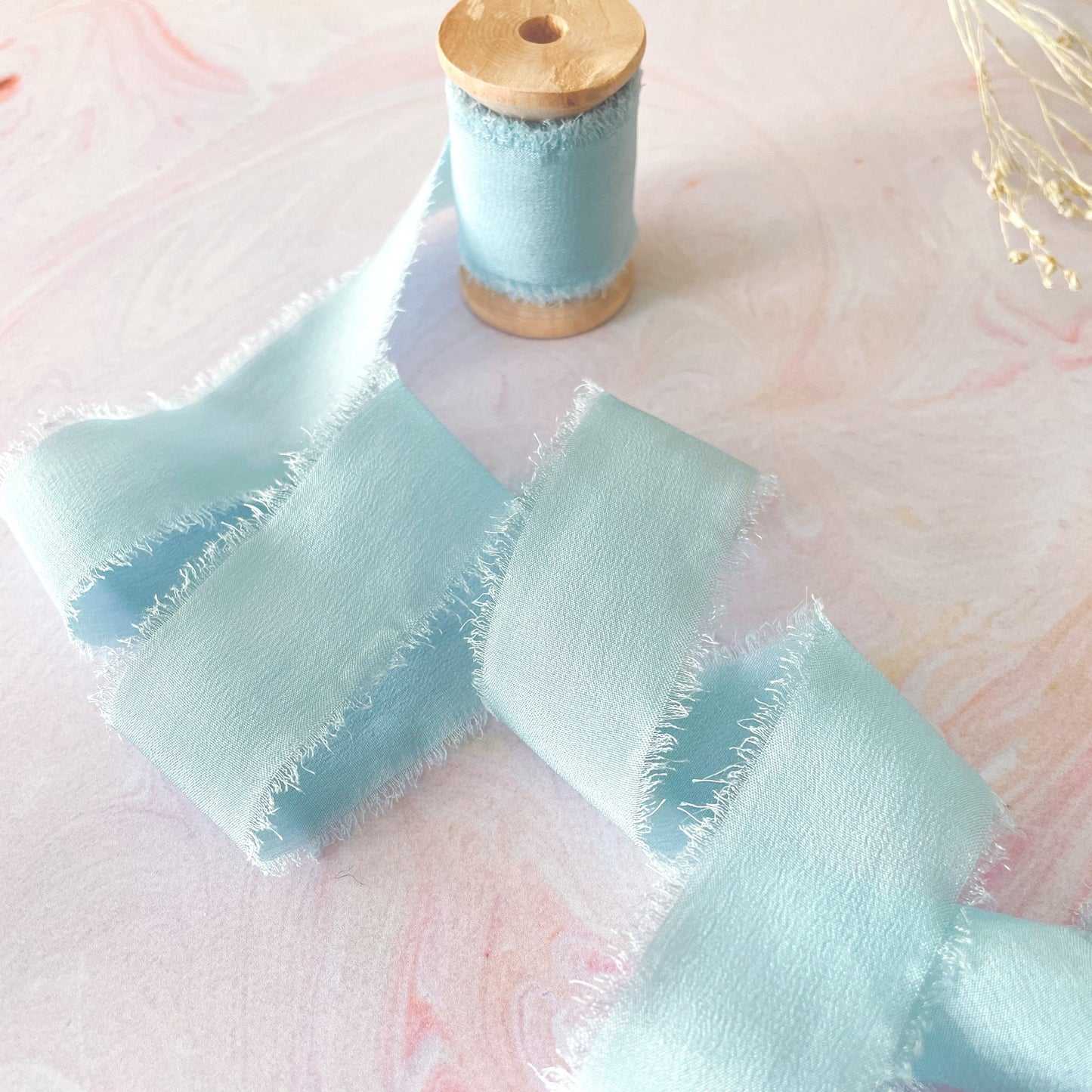 Silk ribbon in dusky pale blue colour.   Luxury habotai silk on a wooden reel.  By The Natural Paper Company.