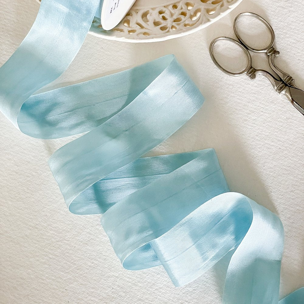 Pale blue silk ribbon for crafts.  Fine silk ribbon with a closed edge.  Sold by the meter.  By The Natural Paper Company