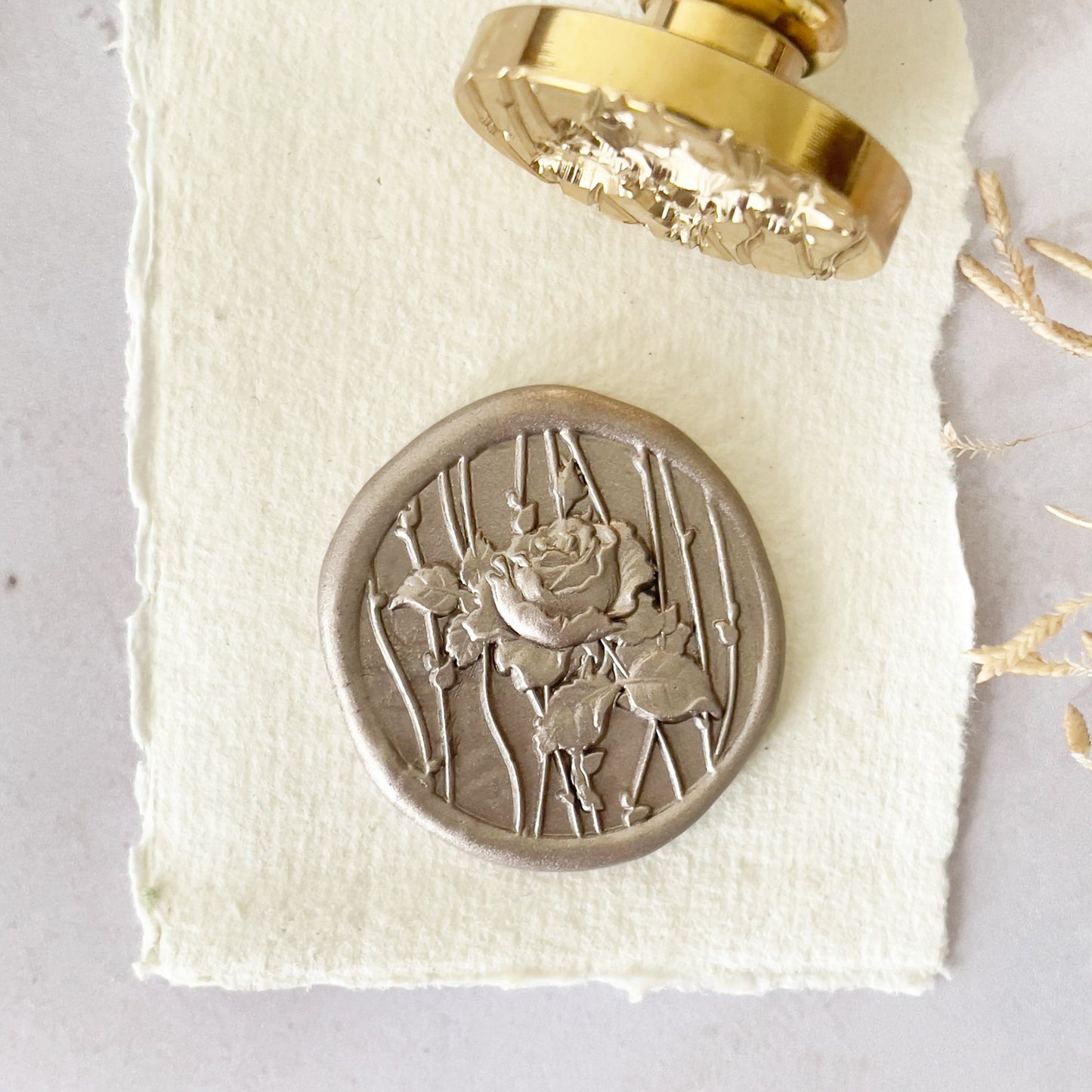 Wax stamp with a rose and vine pattern.  Pretty floral wax seal stamp with a brass head and wooden handle.  Perfect for adding wax seals to invitations, stationery, envelopes, gift wrapping and corporate branding.  By The Natural Paper Company                                                                                                                                                