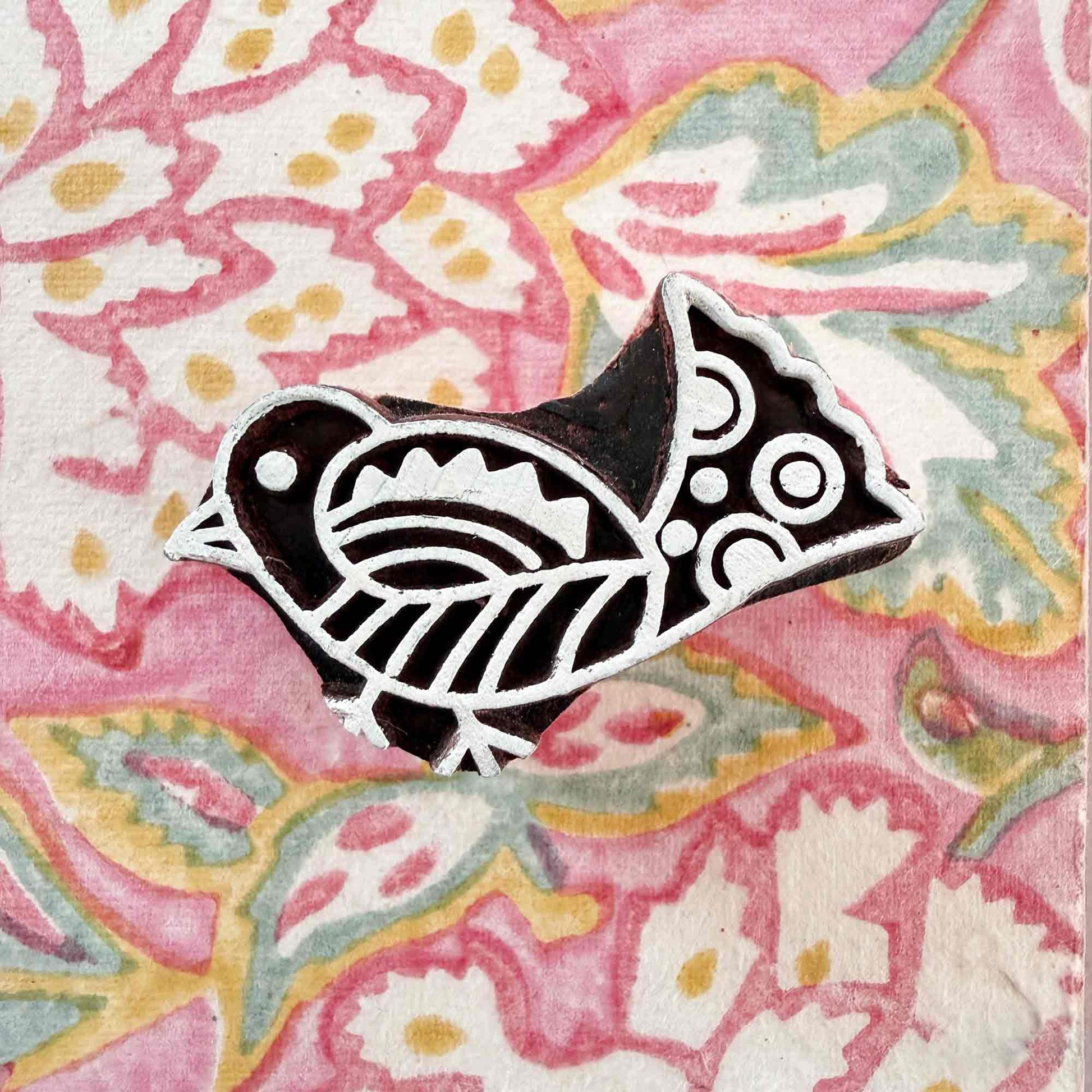 bird design wooden stamp on a wood block pattern background