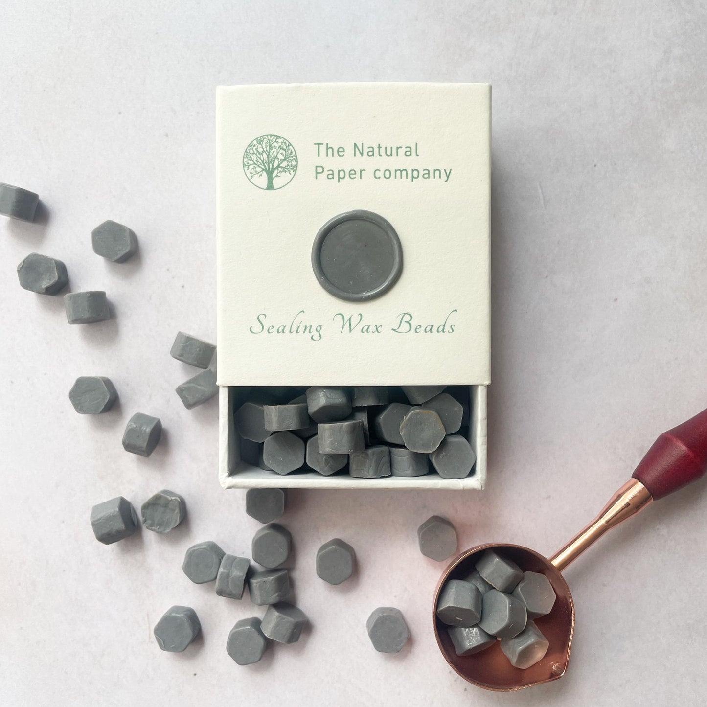 Box of eco friendly sealing wax beads in graphite grey.  Grey wax to make wax seals for invitations, envelope, gift wrapping and packaging.  By The Natural paper Company