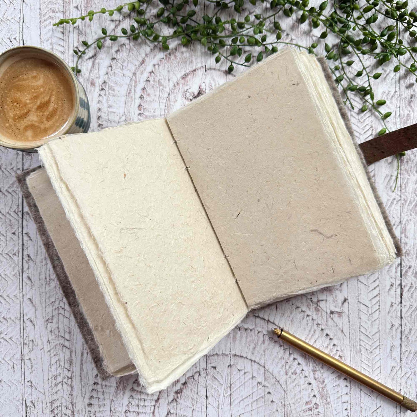 Open A5 notebook showing textured Lokta paper pages, wool and leather cover, The Natural Paper Company