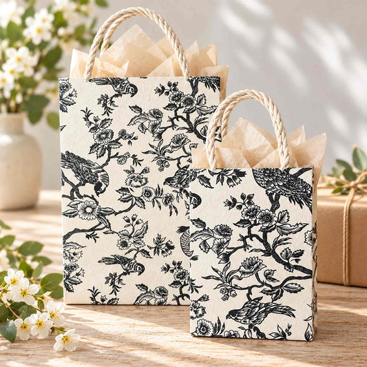 Large and small Bird Garden Lokta paper gift bags filled with tissue paper showing black and white botanical bird design