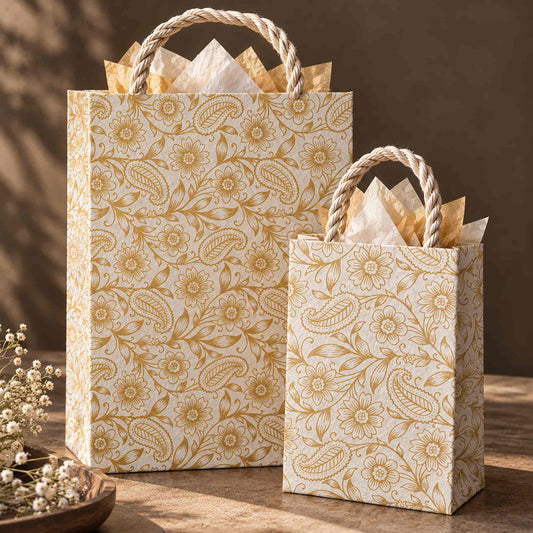 Auralia handmade Lokta paper gift bags in large and small sizes with gold botanical designs and decorative tissue paper.