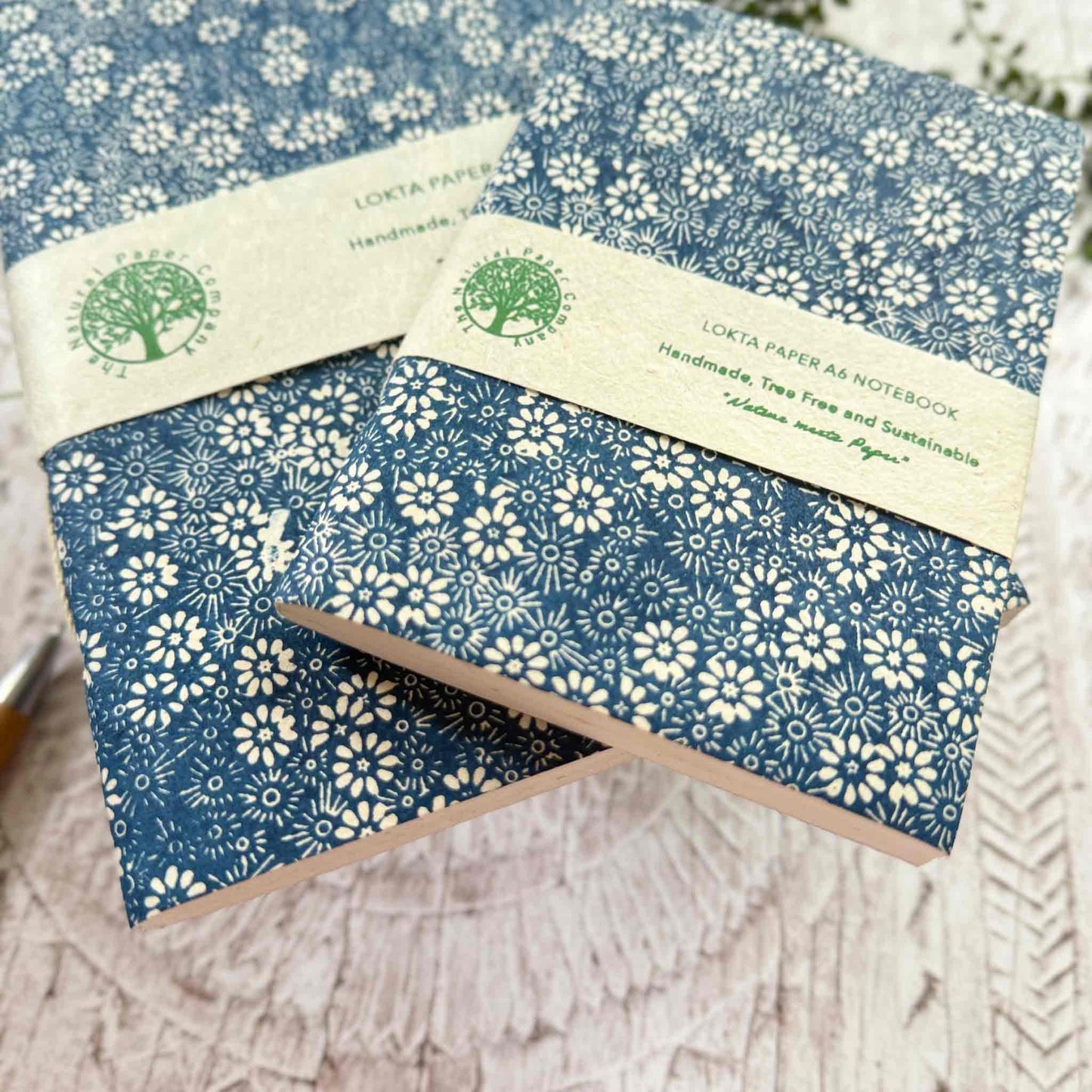 Two Bellis Blue Lokta paper notebooks in A5 and A6 sizes, with hand-printed blue floral covers. Handcrafted in Nepal using 100% natural Lokta paper and traditional hand-stitched binding. Eco-friendly, tree-free notebooks from The Natural Paper Company