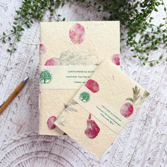A5 and A6 Lokta notebooks from The Natural Paper Company, wrapped with branded band, decorated with Mugwort leaves and Bougainvillea petals
