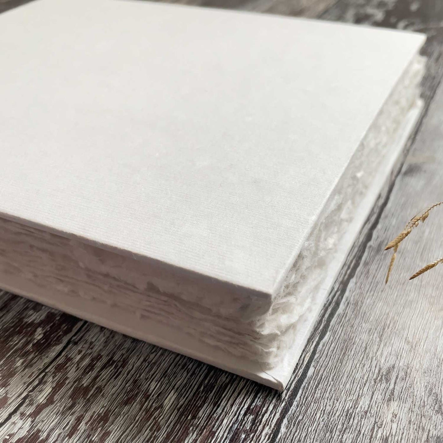 Handmade paper blank book with 100 pages.  Perfect to add your own decorations.  This blank white book has a hard cover.  It's perfect for using as an artist watercolour pad; a wedding guest book; a personalised journal or notebook.  By The Natural Paper Company