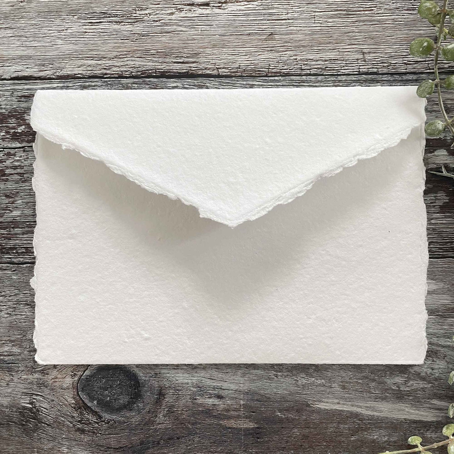 Blank pocket invitation made from handmade card in white.   White handmade paper invitation with a deckled edge pointed flap and internal pocket for guest information .5 x 7 Handmade Card Pocket Invitation in Premium White.  By The Natural Paper Company