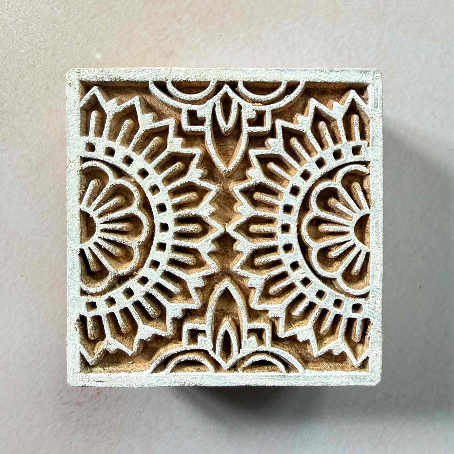 Wooden stamp block with intricate floral pattern for creating repeat prints