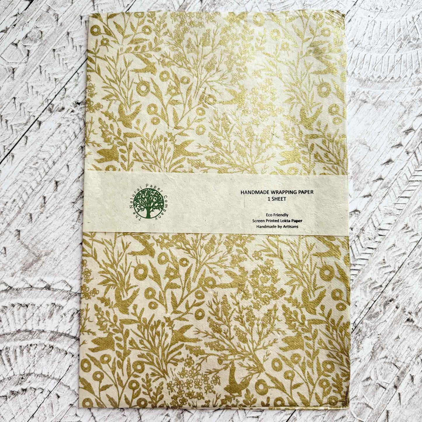 Handmade wrapping paper sheet with gold leaf pattern on a textured surface