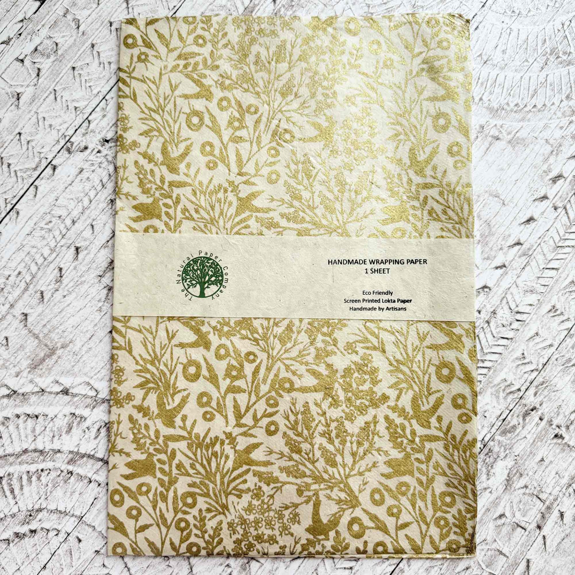 Handmade wrapping paper sheet with gold leaf pattern on a textured surface
