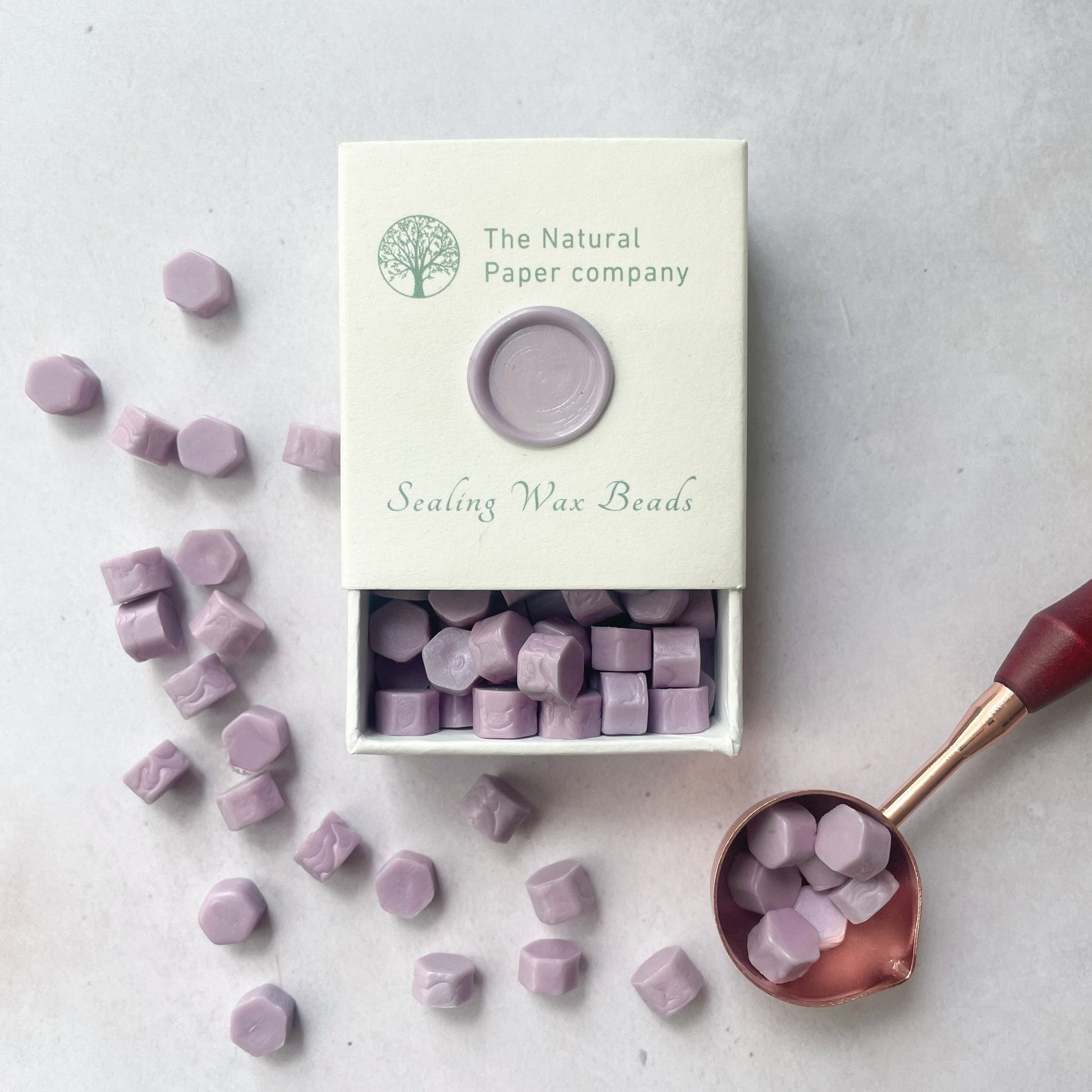 Box of small wax beads to make wax seals.  Eco friendly wax seals in lilac.  Plastic free, paraffin free and biodegradable wax for decorating invitations, stationery, envelopes and packaging.  By The Natural paper Company