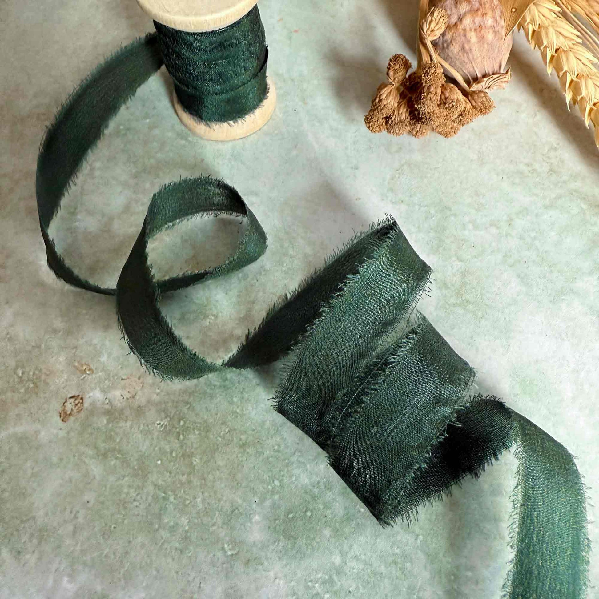 dark green silk ribbon on a wooden reel
