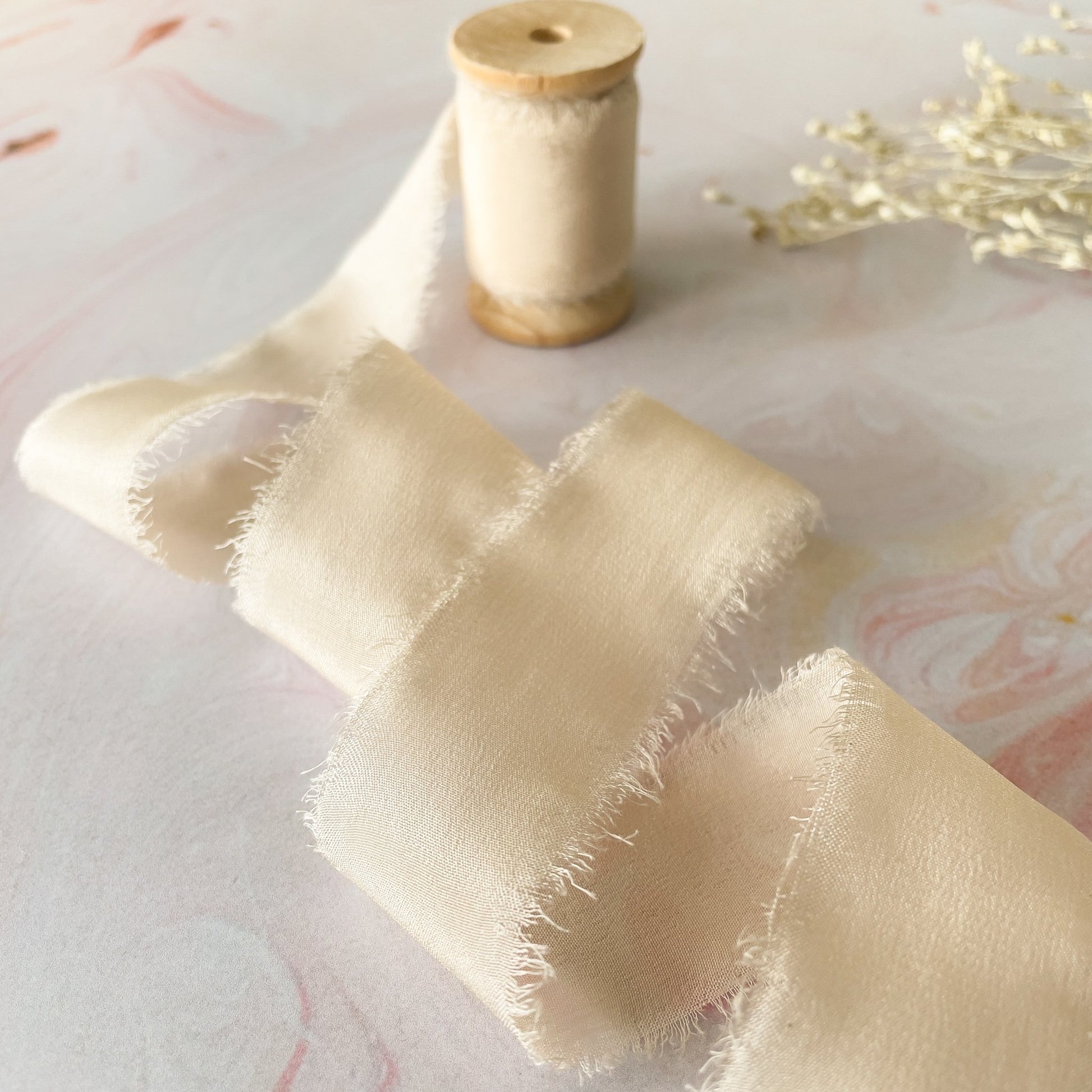 Decorative silk ribbon in ivory.  Fine habotai silk ribbon with a rayed edge.  By The Natural Paper Company.