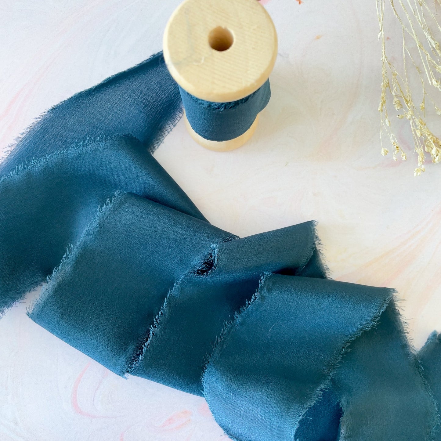 Silk ribbon for crafts.  Navy silk ribbon with a frayed edge,  Sold on a wooden reel.  By The Natural Paper Company