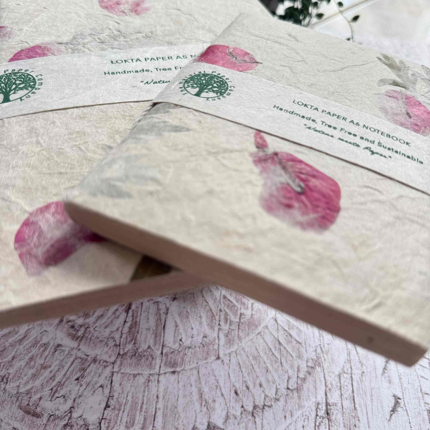 Detailed view of A5 and A6 Lokta notebooks, showing texture, pressed Mugwort and Bougainvillea, and The Natural Paper Company label