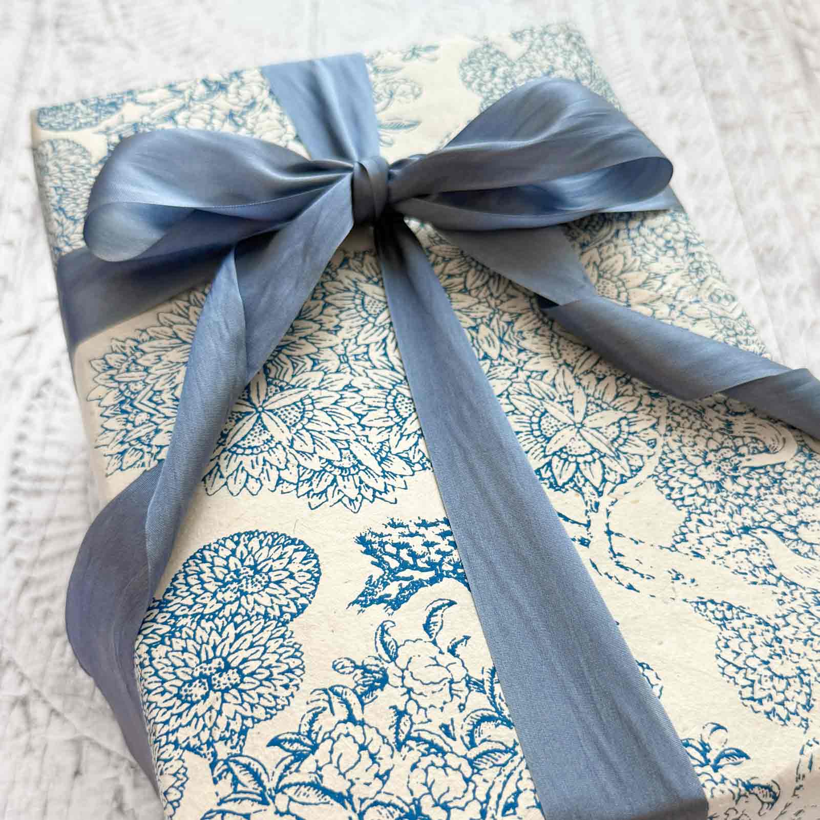 blue and white gift wrap with a silk ribbon.  Screen printed lokta paper 