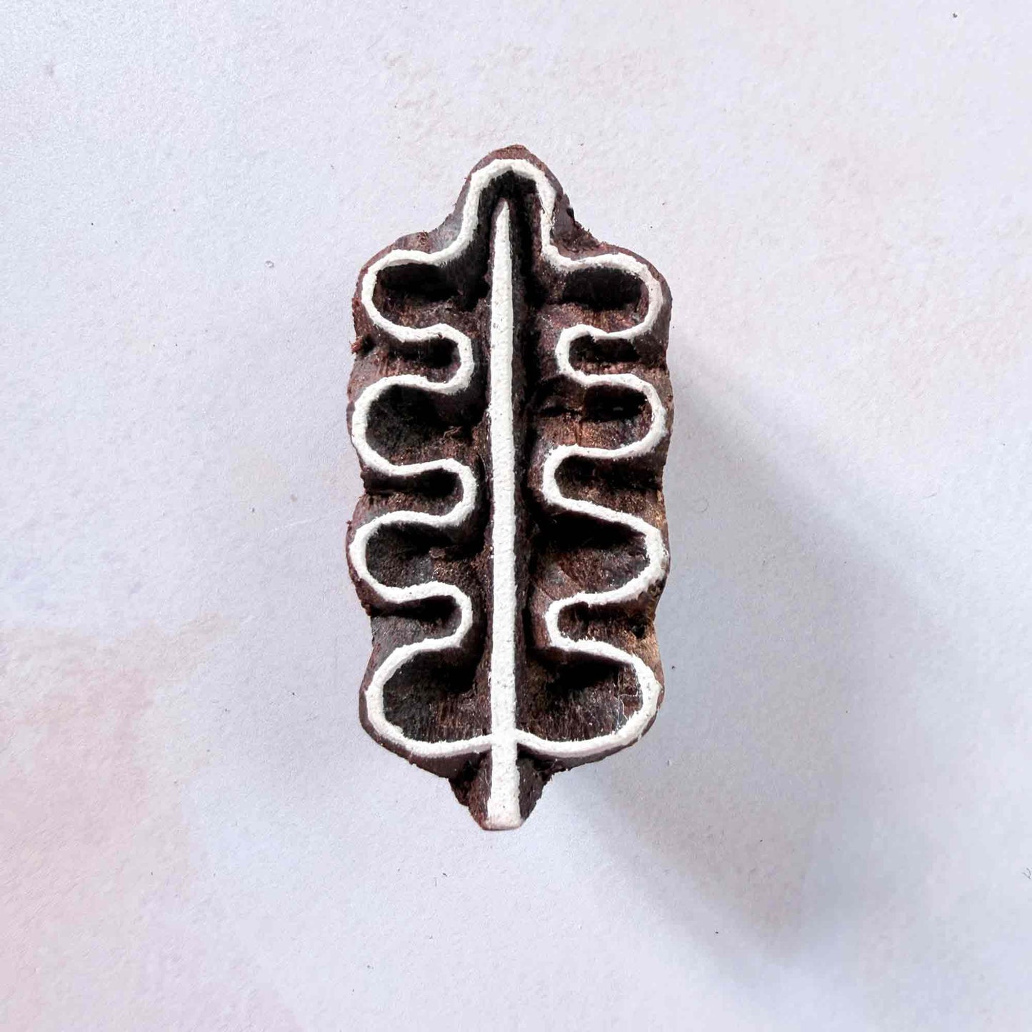Hand-carved Oak Leaf Indian wood block stamp — symmetrical leaf shape with central vein face-on view on soft pale background, botanical motif traditional printing block from India