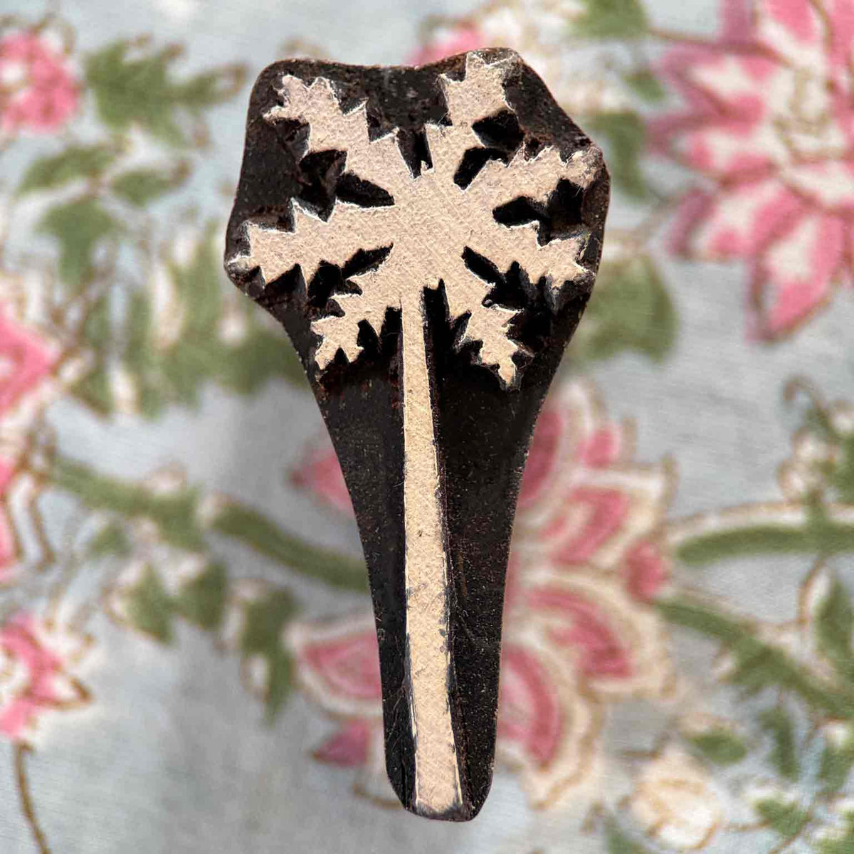 Palm Tree wooden stamp with slender trunk and stylised leafy canopy on a block printed fabric background