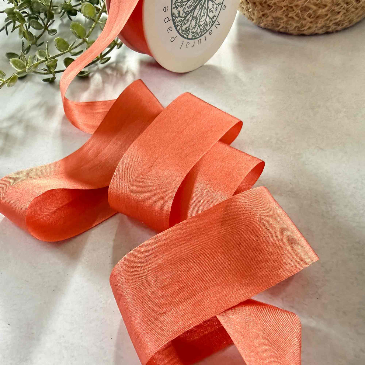 Wide Paprika Silk Ribbon styled with greenery for weddings, floristry, stationery, and luxury gift wrapping.
