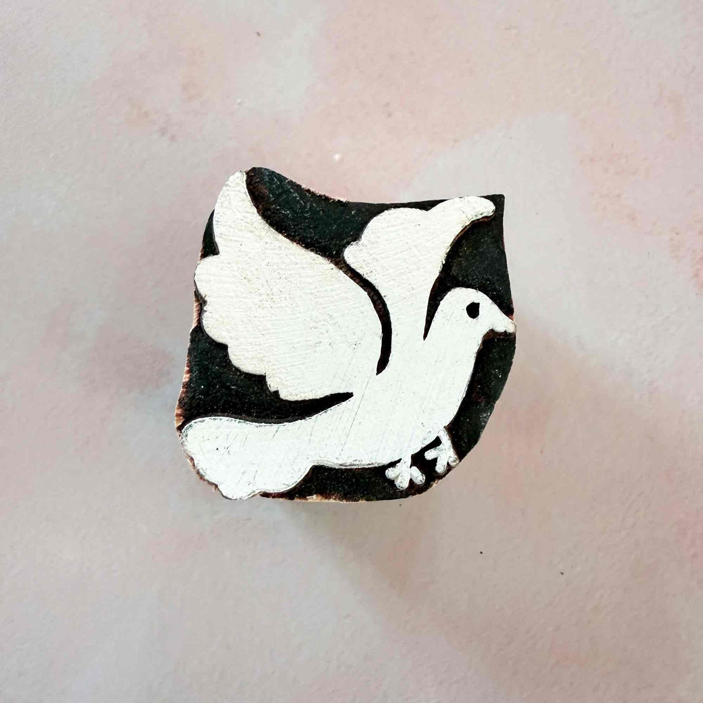 wooden stamp with the design of a dove in flight