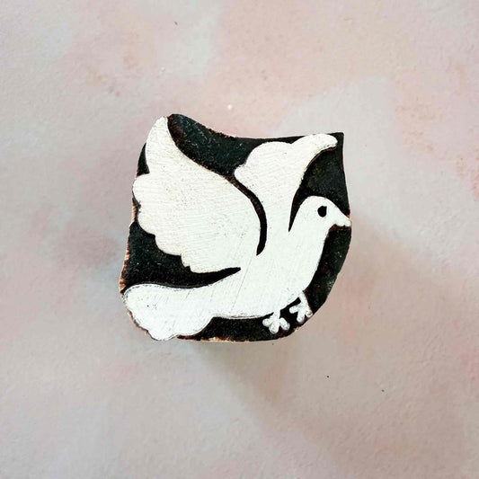 wooden stamp with the design of a dove in flight