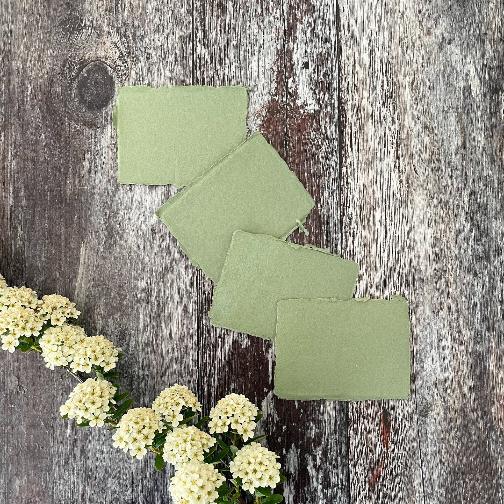 Sage green place cards made from handmade recycled paper with a deckled edge.  By The Natural paper Company