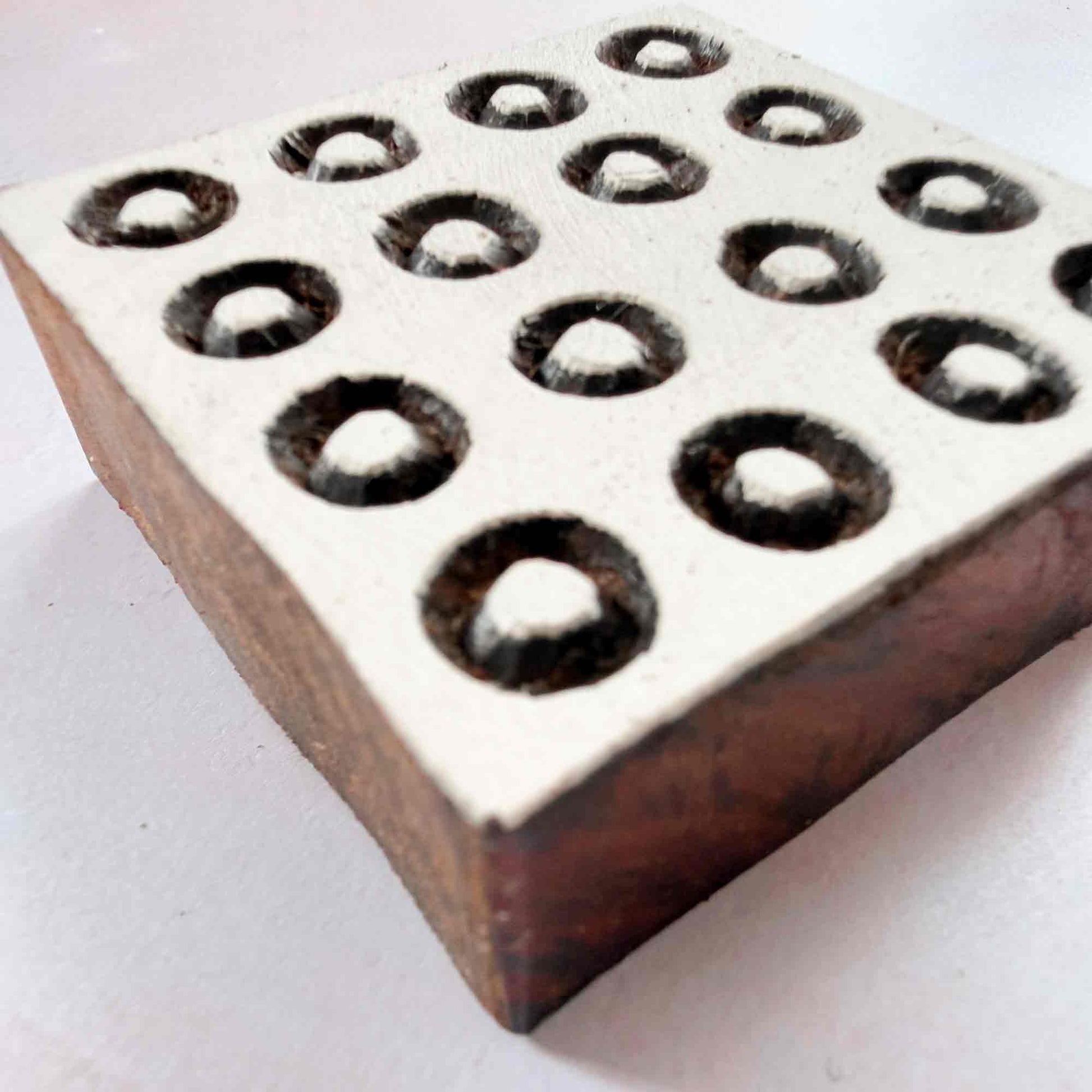 Polkas Indian wood block stamp — square ring dot grid viewed from side on neutral background, hand-carved traditional printing block with raised outlined circles