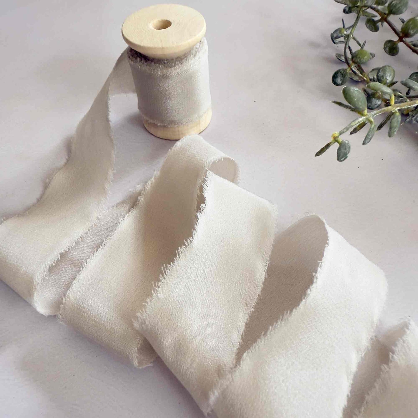 Putty colour silk ribbon with a frayed edge.  Neutral silk ribbon