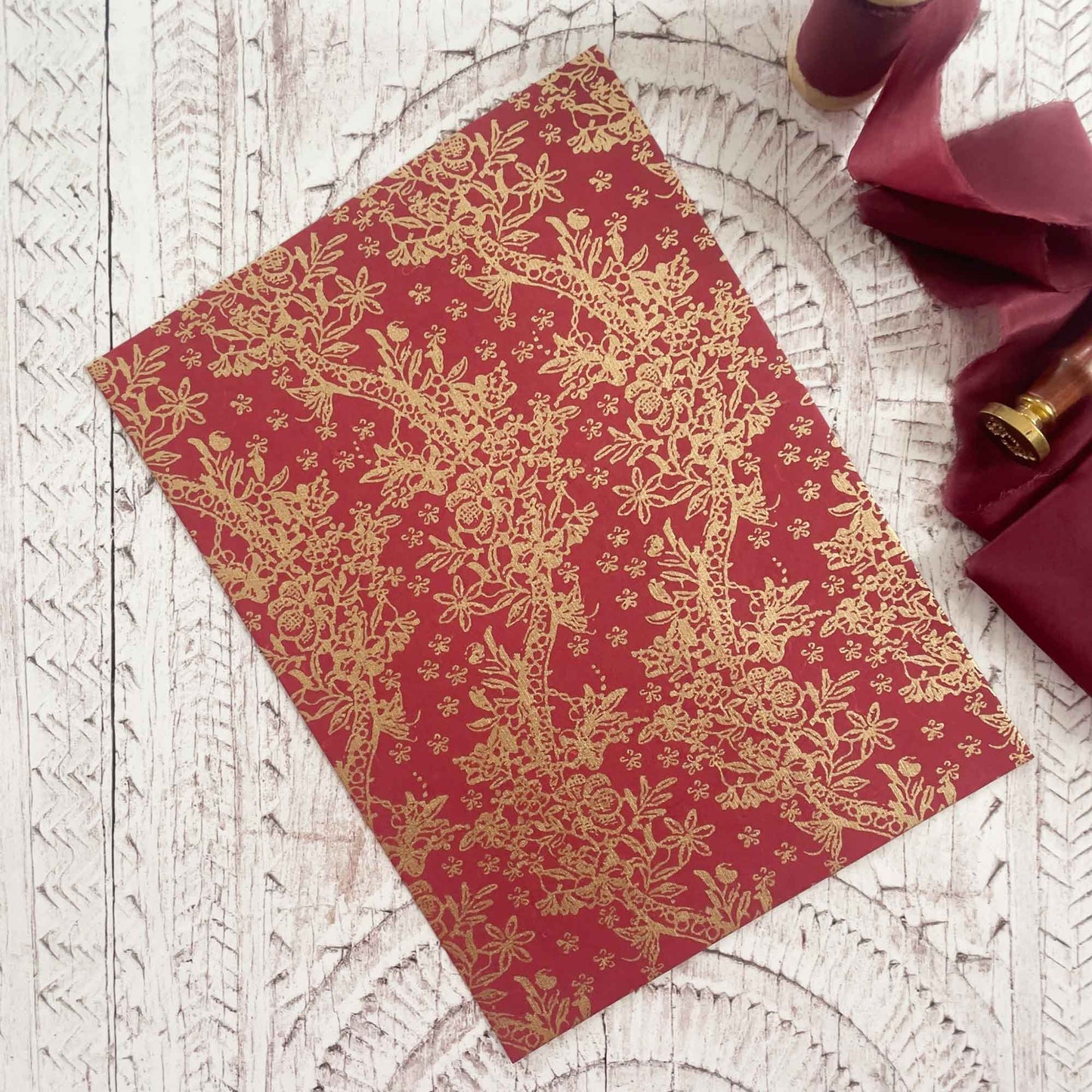 Red recycled cotton rag paper with printed gold pattern