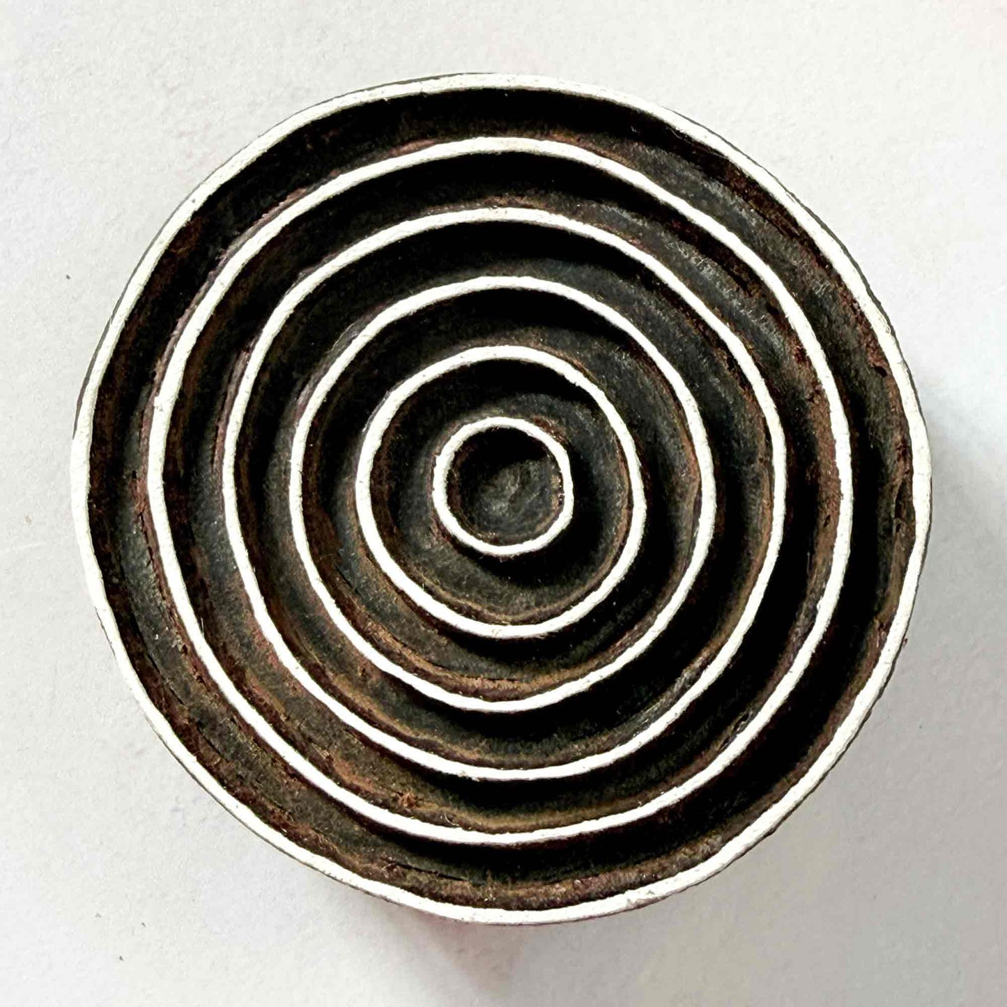 Indian wood block stamp — Ripple design, seven smooth concentric rings face-on view on soft pale background, flowing ring motif hand-carved wooden stamp, authentic traditional printing block from India