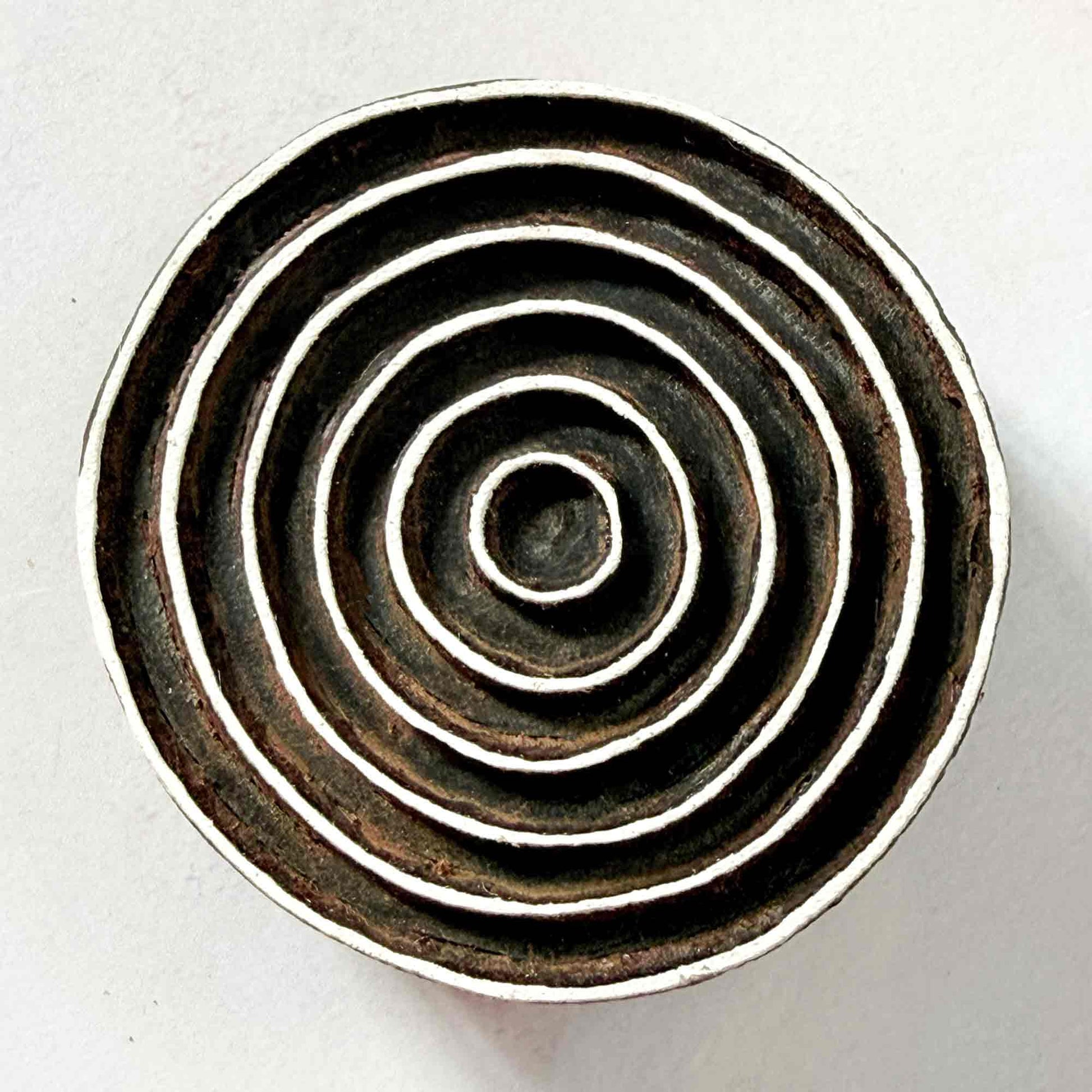 Indian wood block stamp — Ripple design, seven smooth concentric rings face-on view on soft pale background, flowing ring motif hand-carved wooden stamp, authentic traditional printing block from India