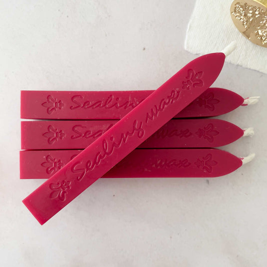 raspberry red sealing wax sticks with wick.  Make bright red stamps and seals with wax