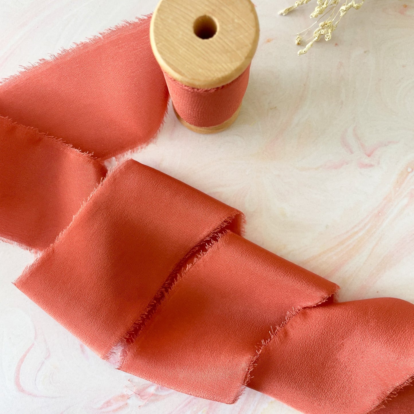 Rust colour silk ribbon.  Luxury habotai silk ribbon in burnt orange.  Perfect for decorating wedding stationery and invitations.  By The Natural Paper Company.