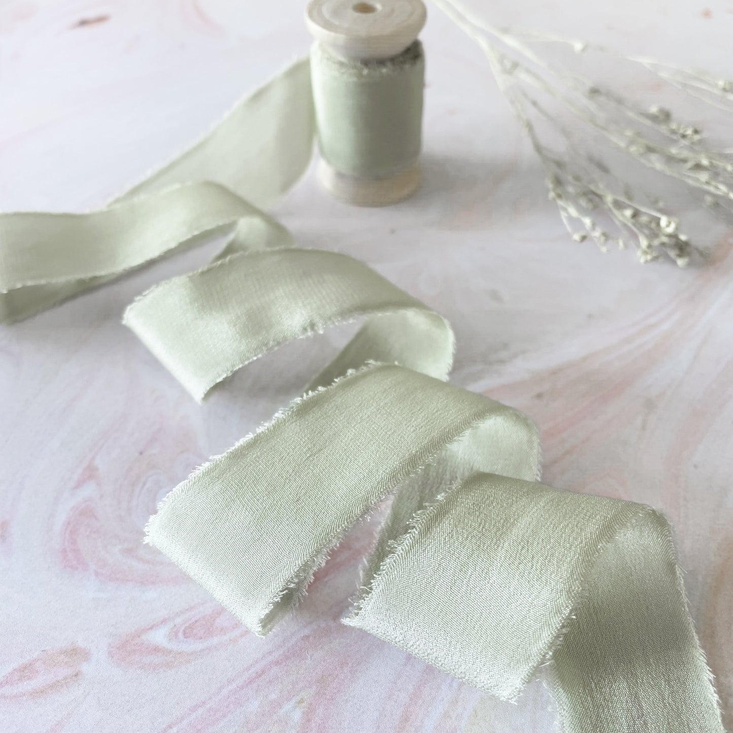 Dusky sage green silk ribbon on a wooden reel.  Delicate silk ribbon for wedding stationery, floristry and crafts