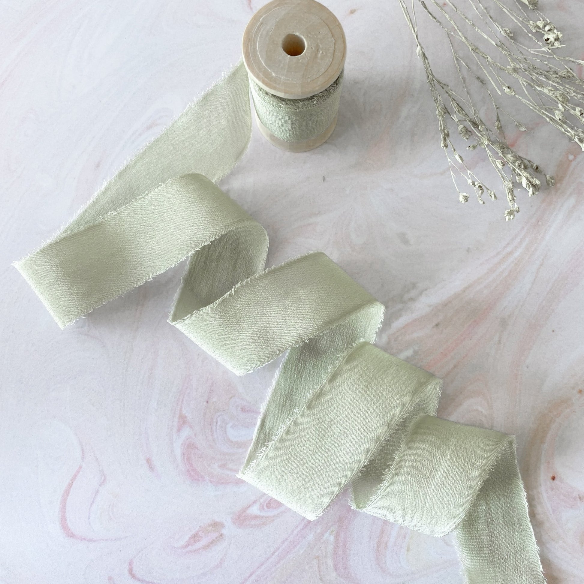 Luxury silk ribbon on a wooden reel.  Fine habotai silk ribbon in sage green.  Perfect for floristry and decorating wedding stationery.  By The Natural Paper Company.