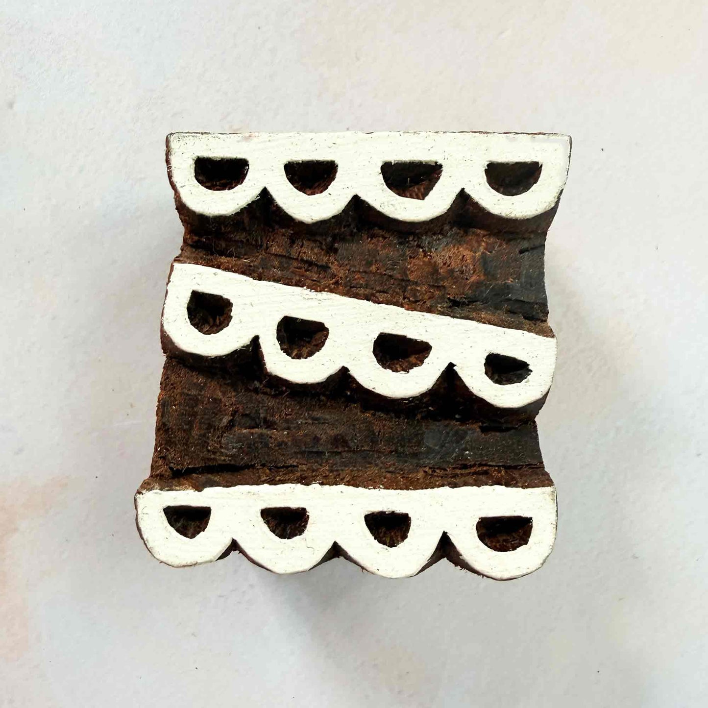 Scallop wooden stamp — bunting-style curved arches design on pale background