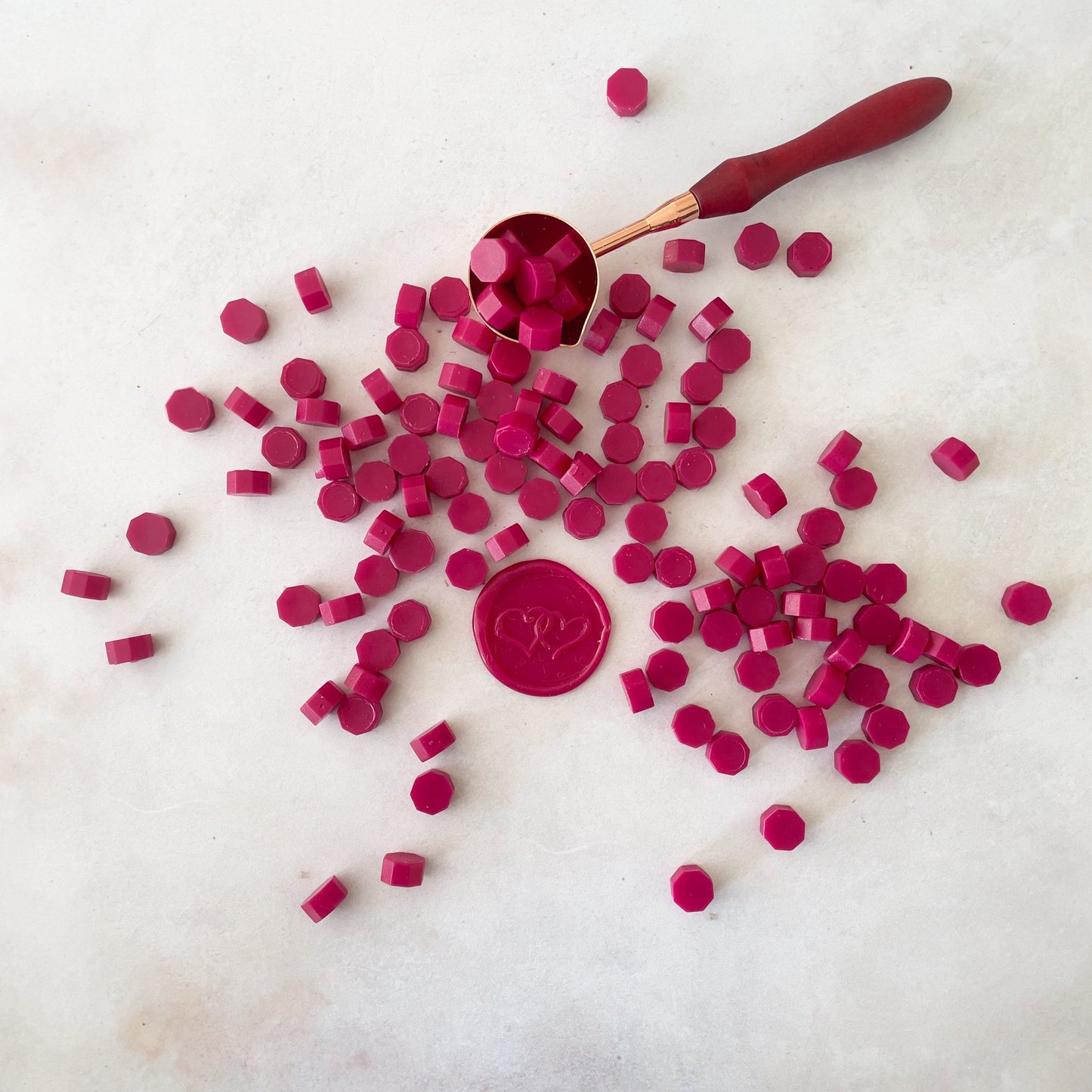 Small beads of wax to make wax seals.  Eco friendly sealing wax beads in bright raspberry red colour.  by The Natural Paper Company  