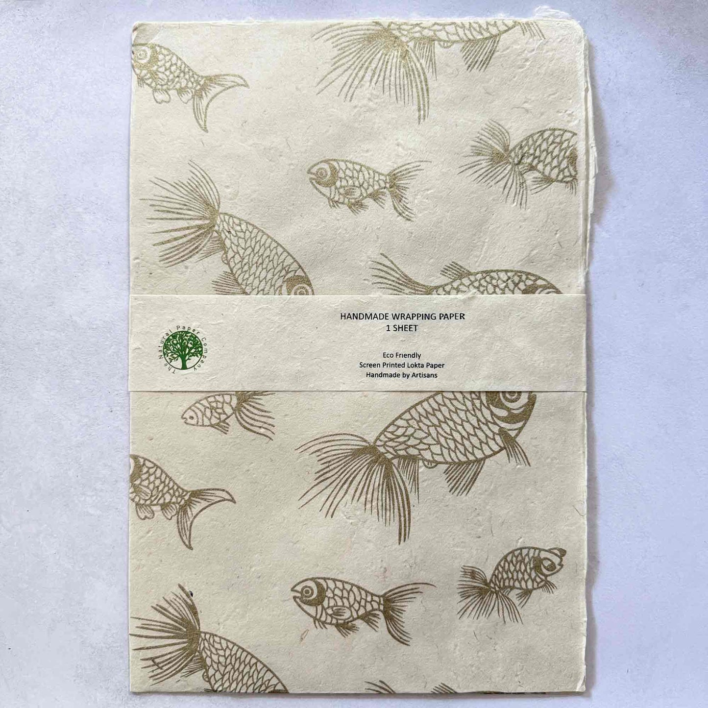 Flat lay of handmade wrapping paper – eco-friendly Lokta paper hand printed with gold fish motifs