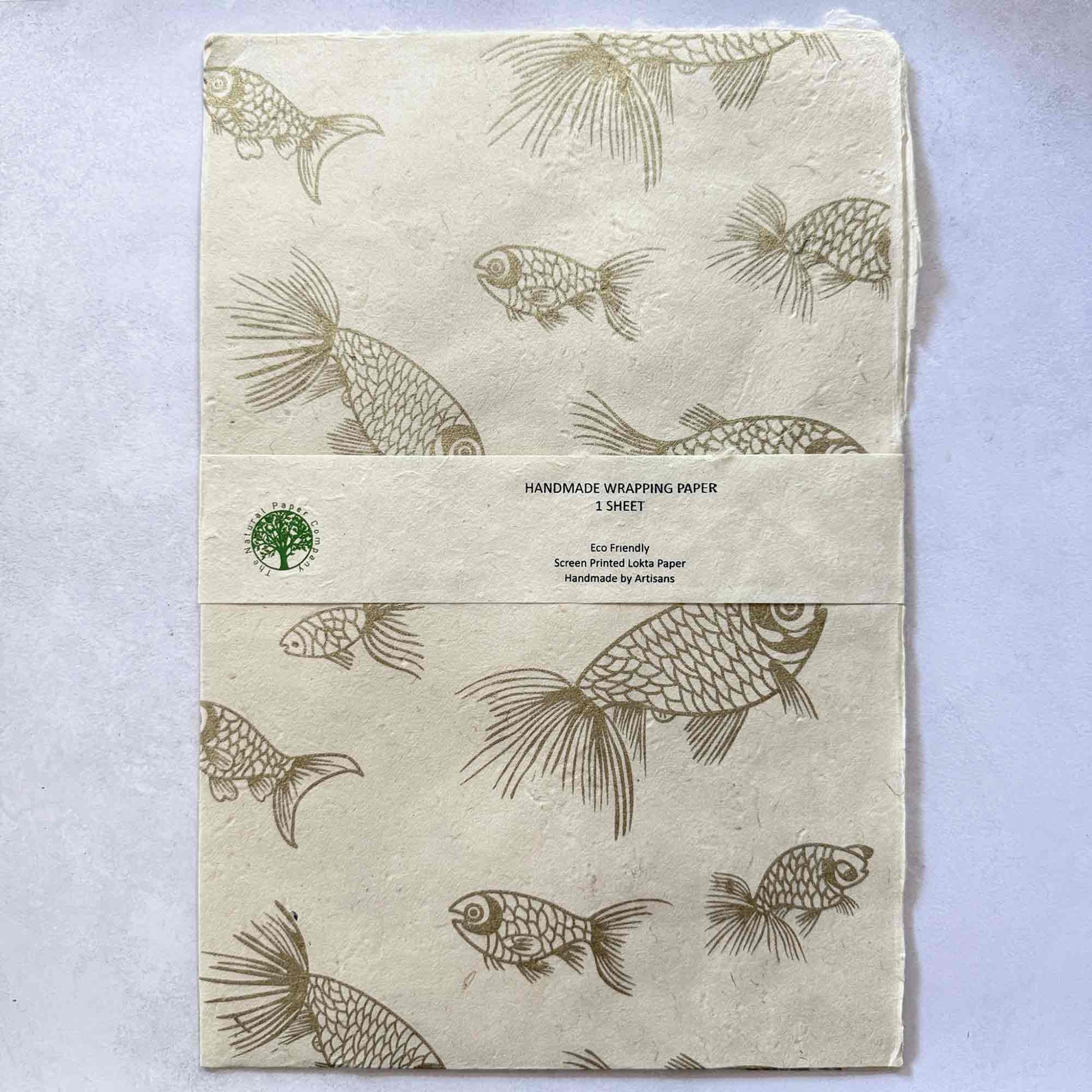 Flat lay of handmade wrapping paper – eco-friendly Lokta paper hand printed with gold fish motifs