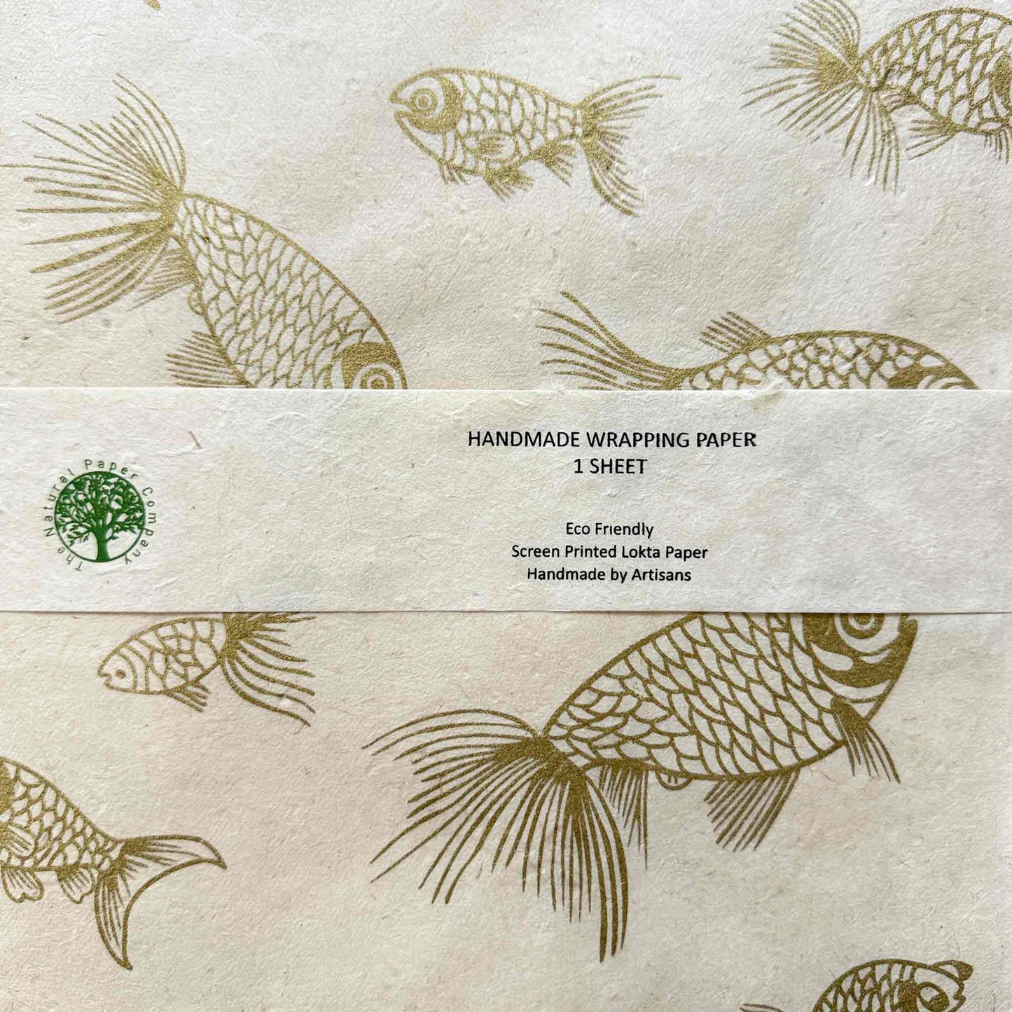 A sheet of handmade lokta wrapping paper featuring a screen-printed pattern of koi fish in gold on a warm cream background, with a branded paper band across the center containing product details.