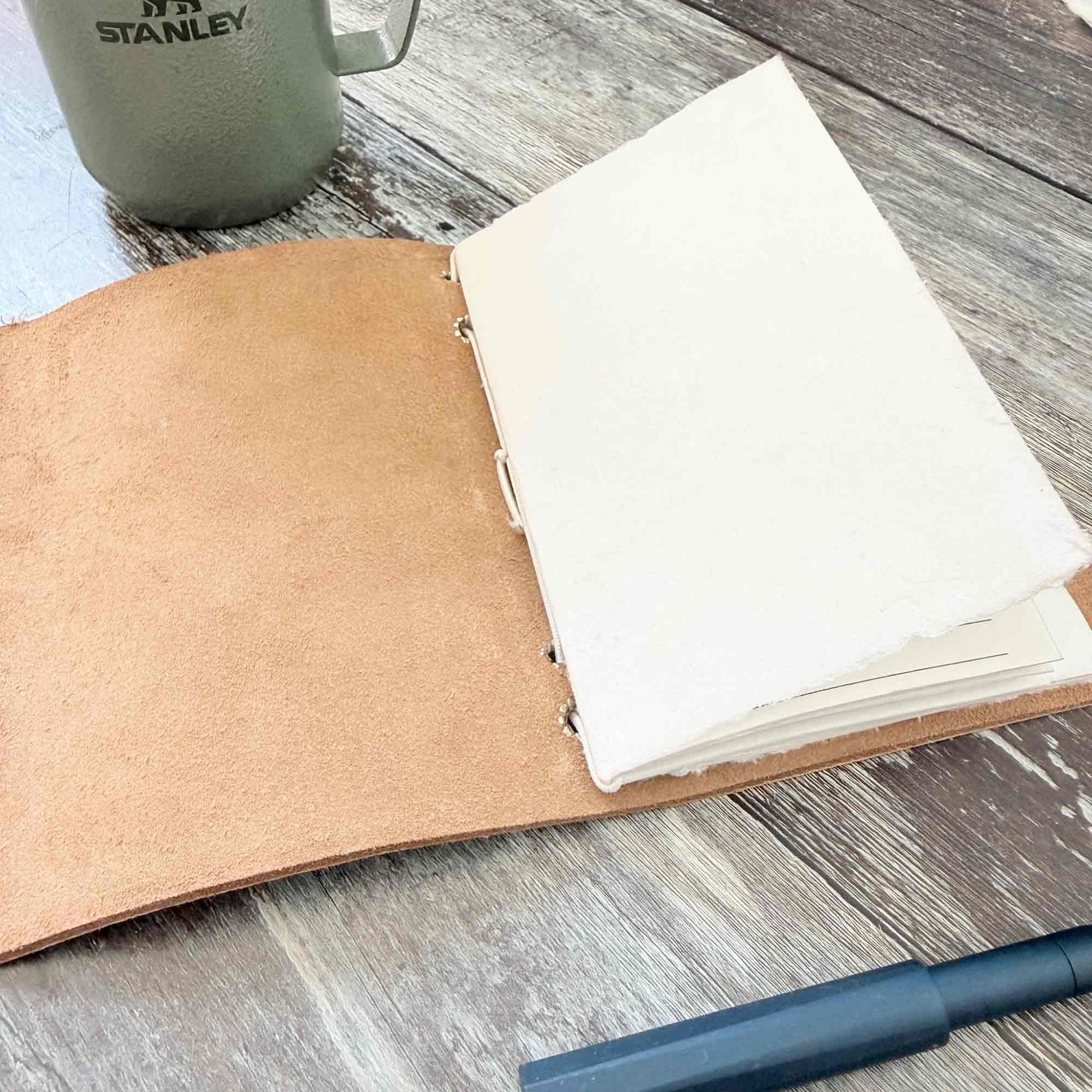 Open silver leather journal with blank handmade cotton paper inserts
