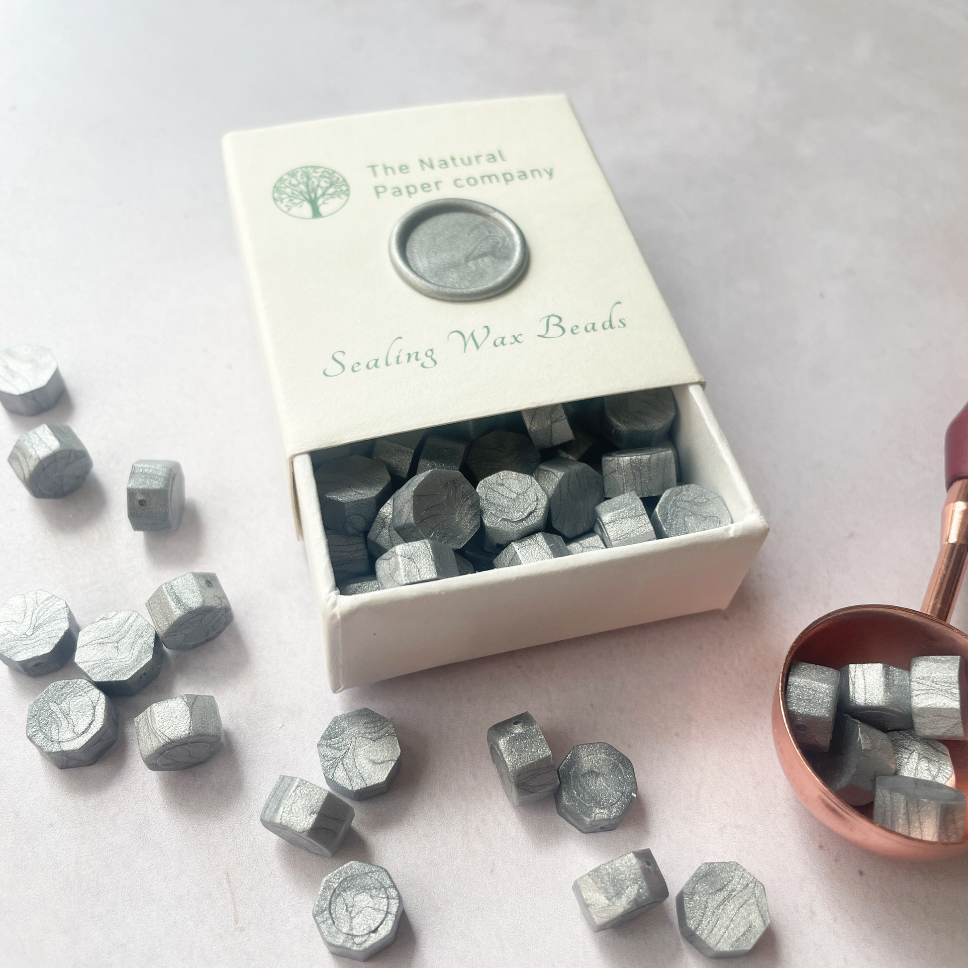 Box of silver sealing wax beads.  Eco friendly silver wax for making wax seals.  Plastic free, paraffin free and biodegradable.  The Natural paper Company