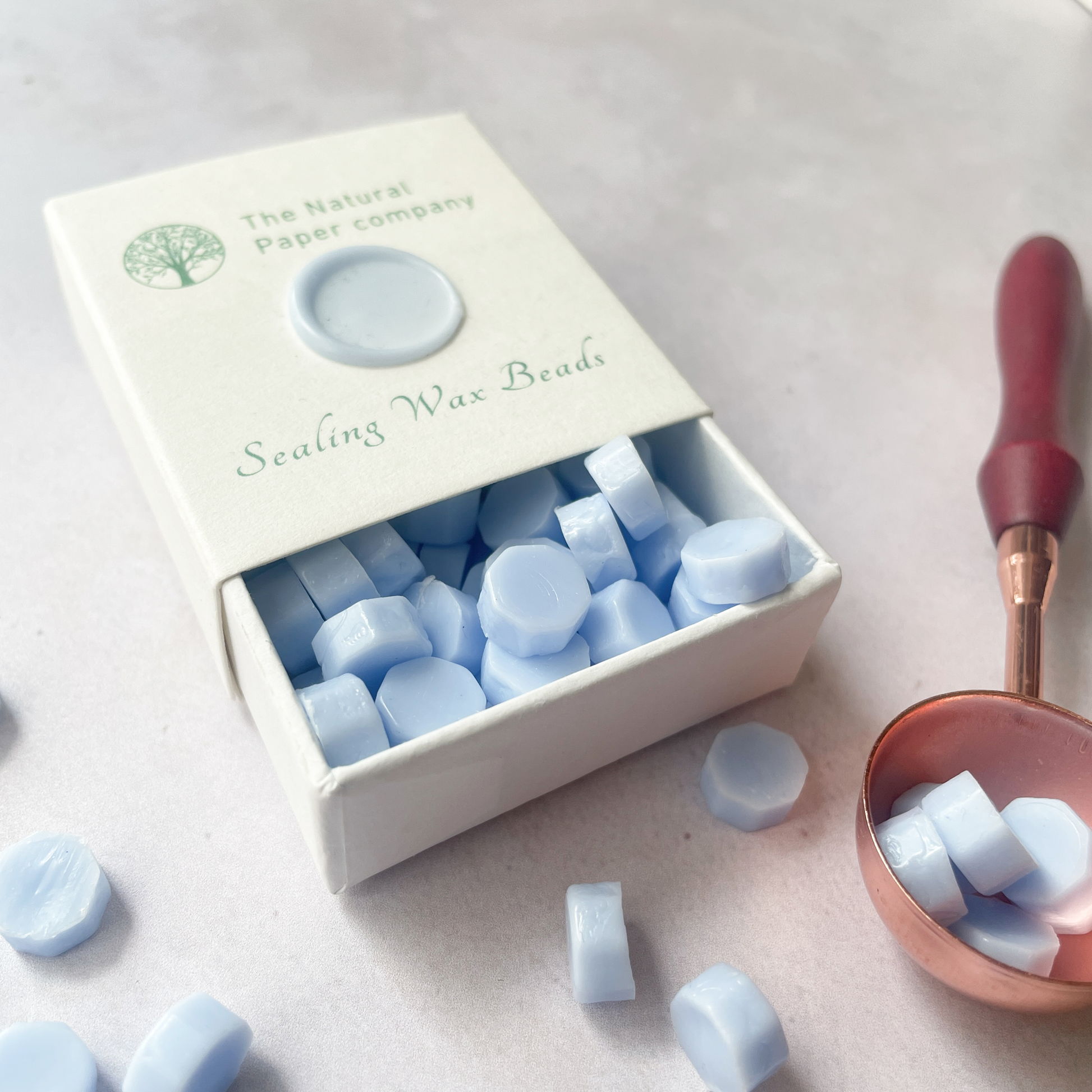 Light blue wax seal beads in a box.  Eco friendly sealing wax beads to make wax seals.  By The Natural paper Company