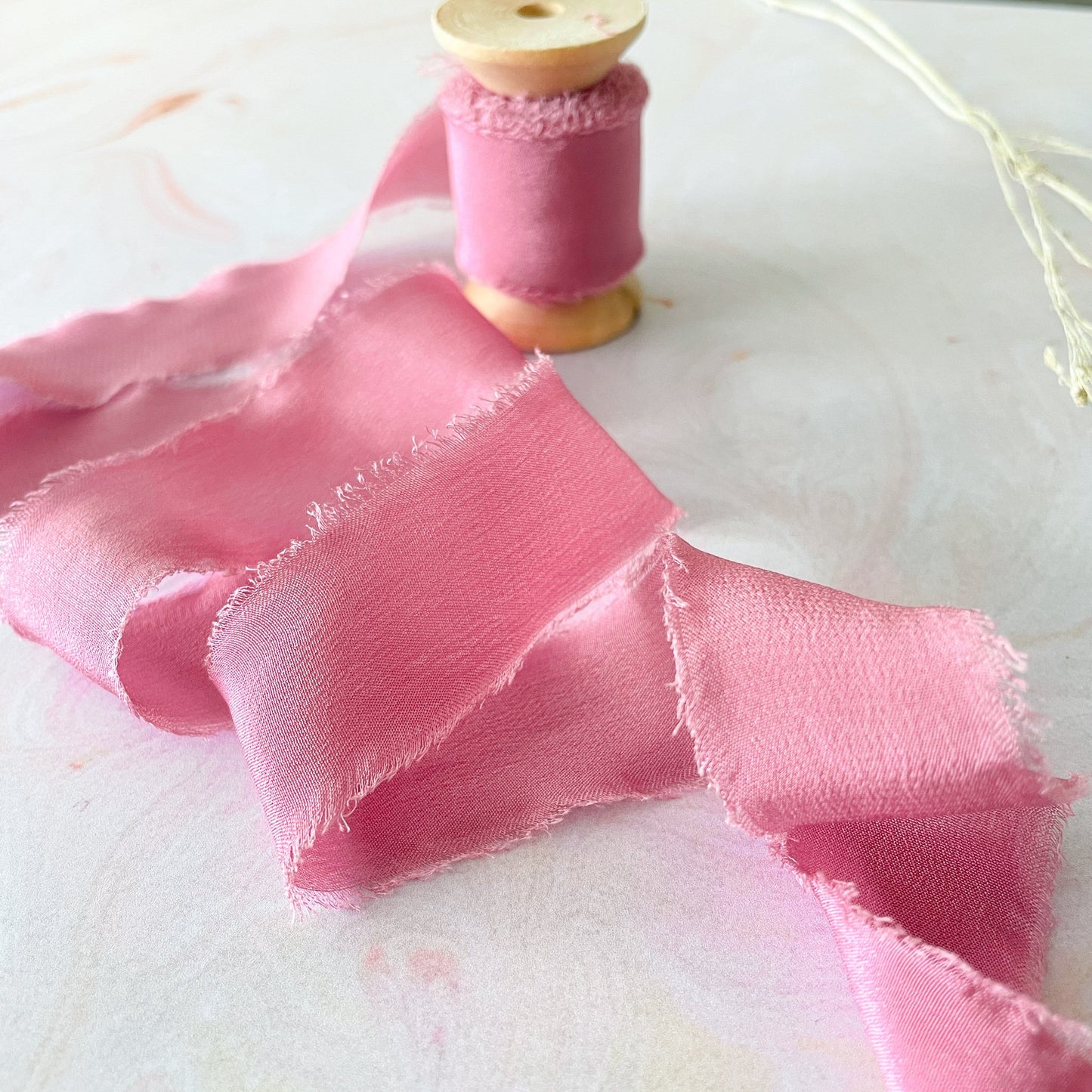 Pink silk ribbon on a wooden spool.  Luxury silk ribbon for floristry, wedding stationery, invitations and crafts.  By The Natural Paper Company.