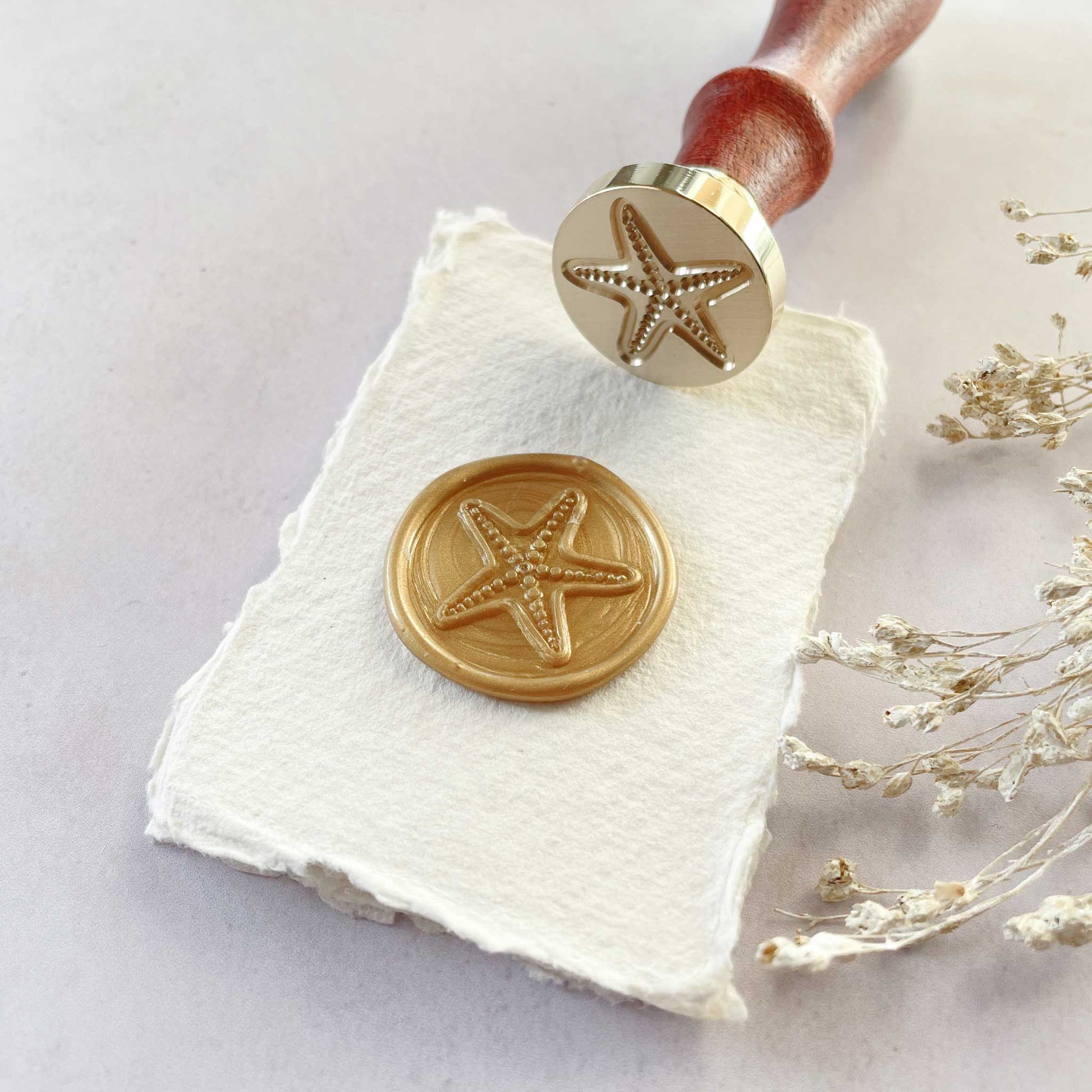 Starfish design wax seal stamp.  Make beach theme wax seals for invitations, stationery, envelopes, cards and crafts.  Traditional brass stamp with a wooden handle.  By The Natural Paper Company