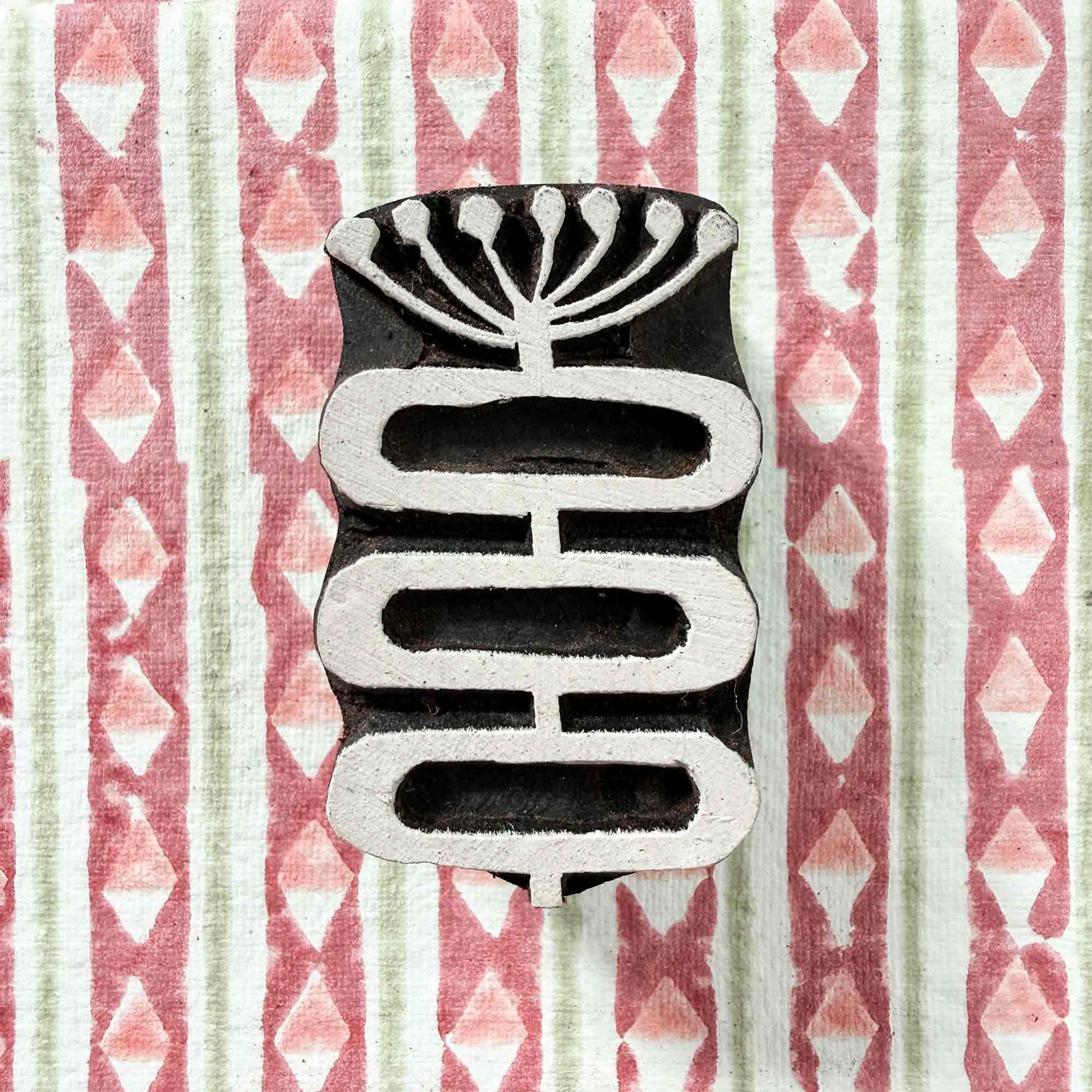 Hand-carved Stem Indian wood block stamp — botanical seed head and linked shapes resting on block printed fabric, graceful motif ready for printing, traditional hardwood printing block from India