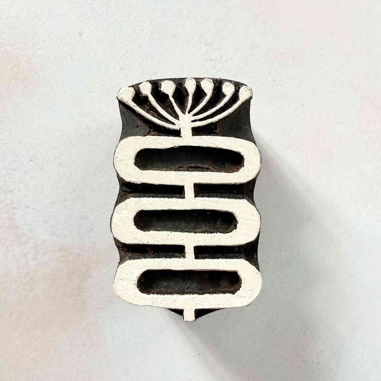 Stem wooden stamp — delicate seed head above three linked rounded forms face-on view on soft pale background, handcrafted Indian printing block with flowing organic design