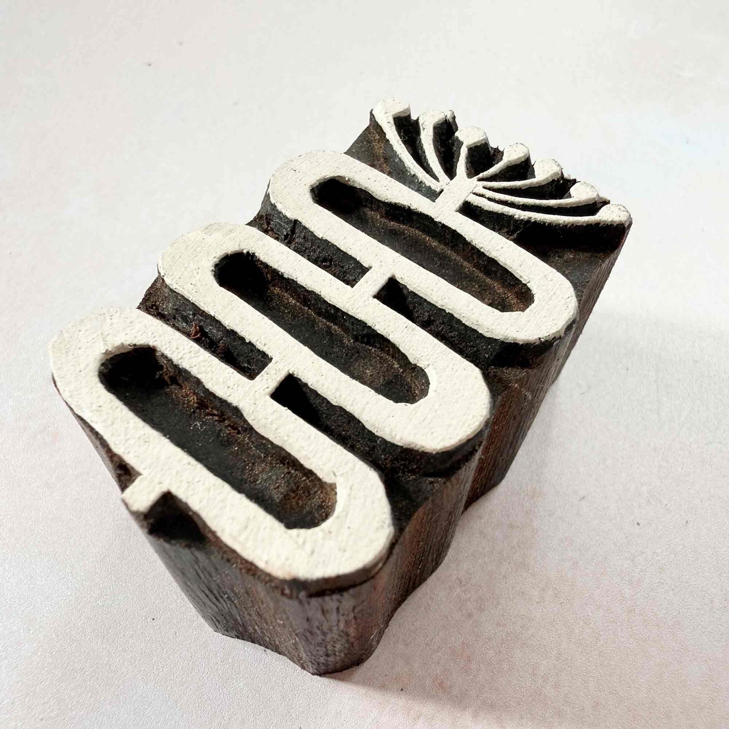 Stem Indian wood block stamp — graceful botanical design viewed from side, showing carved depth and smooth curved form, handcrafted hardwood printing block on neutral background